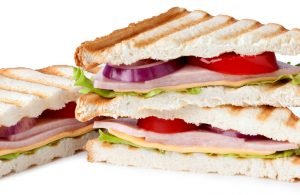 Sandwich with bacon and vegetables on white background